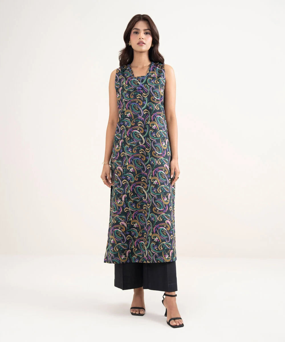 Woman wearing a sleeveless patterned dress on a white background